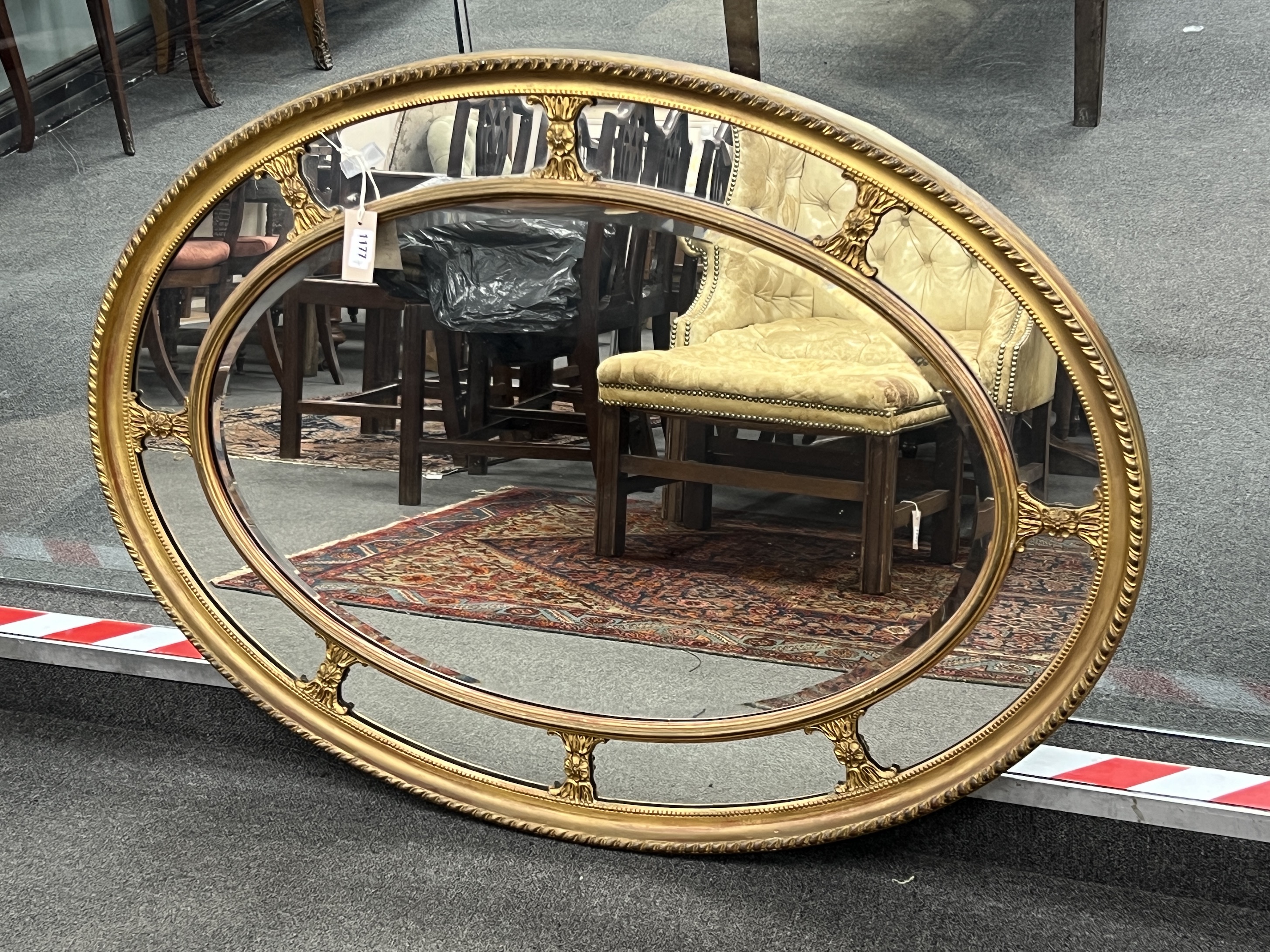 An oval giltwood and composition marginal plate wall mirror, width 113cm, height 83cm